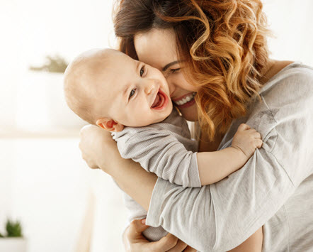 Mother hugging a laughing baby Birth Trauma